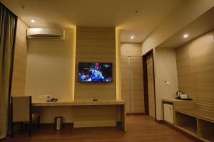 古尔冈GOA COUNTRY CLUB的酒店客房的墙上配有电视