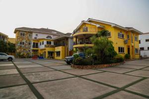 阿克拉米当蒂酒店的停车场有黄色的建筑和汽车