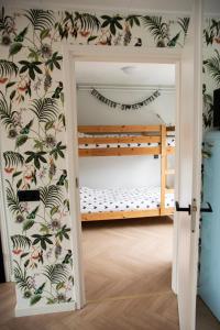 滨海卡特韦克huisje de Strandjutter的客房设有双层床和壁纸覆盖的墙壁。
