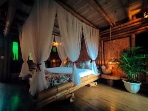 贾丁Cabaña Manantial del Turpial的一间卧室配有带窗帘的天蓬床