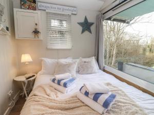 布兰德福德福鲁姆Art Studio的卧室配有带枕头的床铺和窗户。