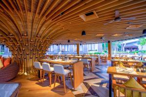 努沙杜瓦巴厘岛努沙杜瓦万怡度假酒店的餐厅设有木制天花板和桌椅