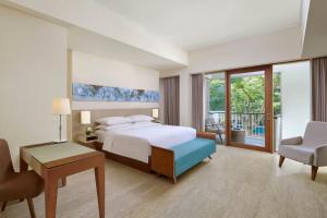 努沙杜瓦巴厘岛努沙杜瓦万怡度假酒店的酒店客房配有一张床、一张桌子和一把椅子。