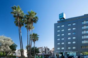 阿尔赫西拉斯AC Hotel Algeciras by Marriott的一座楼前有棕榈树的酒店