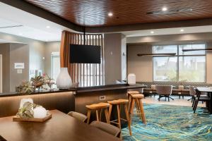 卡纳维拉尔角SpringHill Suites by Marriott Cape Canaveral Cocoa Beach的一间设有桌椅和平面电视的等候室