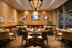 盐湖城盐湖城市中心万豪酒店的一间带桌椅和吊灯的用餐室