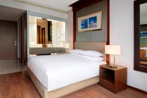 首尔首尔时代广场万怡酒店的卧室配有一张白色大床和镜子