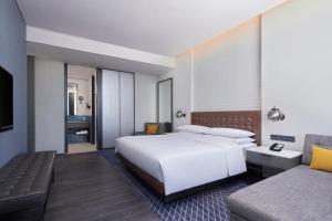 天津国家会展中心天津福朋喜来登酒店的卧室配有一张白色的大床和一张沙发。