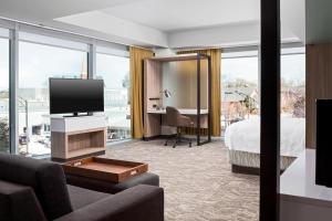 格林维尔SpringHill Suites by Marriott Greenville Downtown的酒店客房设有电视、床和书桌