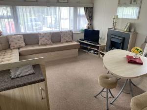 伯顿Borwick Lakes Haven的客厅配有沙发和桌子