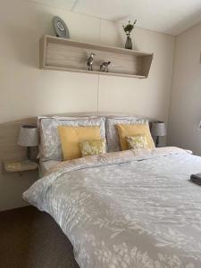 伯顿Borwick Lakes Haven的卧室配有带白色棉被的床