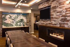 韦纳奇Residence Inn by Marriott Wenatchee的一间带壁炉和电视的用餐室