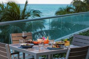 迈阿密海滩迈阿密巴尔港丽思卡尔顿度假村的阳台上的桌子上摆放着食物和饮料