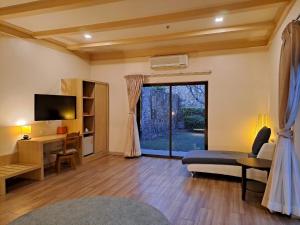 盘蓬PM Lake Mabprachan Pattaya的客厅配有床、书桌和窗户