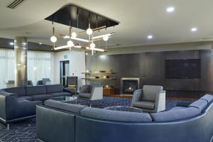 梅德福梅德福机场万怡酒店的大堂配有沙发、电视和壁炉。
