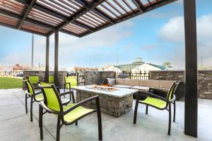 塔拉哈西SpringHill Suites by Marriott Tallahassee North的庭院配有桌椅和火坑