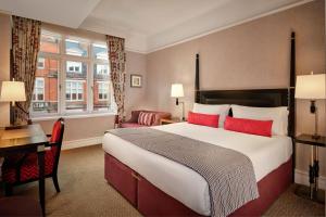 伦敦圣尔敏酒店 - 傲途格精选酒店的酒店客房设有一张大床和一张书桌。
