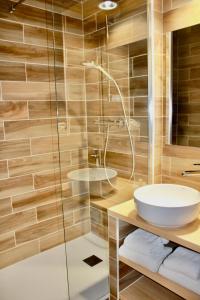 沙布利利斯夏布利酒店的一间带水槽和玻璃淋浴的浴室