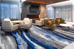斯普林菲尔德Fairfield Inn & Suites Springfield Enfield的酒店大堂设有蓝色地毯和壁炉