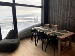 NoresundCosy apartment with ski in/out的配有大窗户的客房内的桌椅