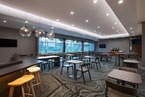 韦科SpringHill Suites Waco的餐厅设有桌椅和窗户。