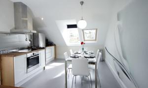 巴斯Bath View Apartments的厨房配有带白色椅子的桌子