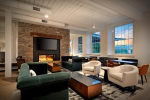 麦迪逊Fairfield Inn & Suites Madison Historic Eagle Cotton Mill的带沙发和椅子的客厅以及壁炉