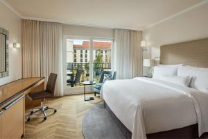 柏林The Westin Grand Berlin的酒店客房设有一张大床和一张书桌。