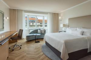 柏林The Westin Grand Berlin的酒店客房设有一张大床和一张书桌。