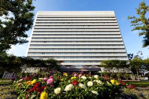 科斯塔梅萨The Westin South Coast Plaza, Costa Mesa的一座高大的建筑,前面有鲜花