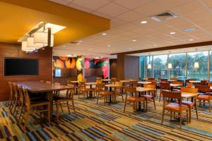 奥兰多奥兰多东/中佛罗里达大学体育馆万豪费尔菲尔德套房酒店的用餐室配有桌椅和平面电视。