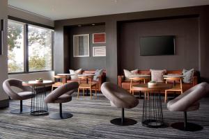 皇后区纽约拉瓜迪亚机场万豪酒店 的一间设有桌椅和平面电视的等候室