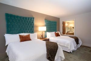 阿什维尔奥托格拉夫系列阿什维尔波西米亚大酒店的酒店客房设有两张床和蓝色床头板