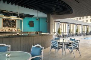 安曼Sheraton Amman Al Nabil Hotel的一间带桌椅的餐厅和一间酒吧