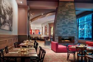 罗利罗利市中心万豪酒店的一间带桌椅和壁炉的餐厅