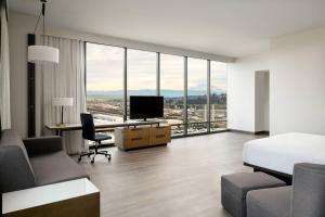 塔科马Marriott Tacoma Downtown的酒店客房配有一张床和一张书桌及一台电视