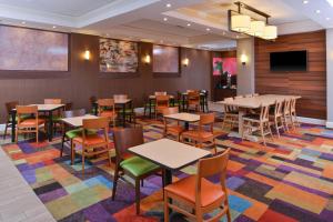 奥尔巴尼基恩市中心万豪费尔菲尔德酒店的一间用餐室,配有桌椅,铺着色彩缤纷的地毯