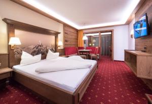 阿尔卑巴赫Hotel Alphof Alpbach的酒店客房设有一张大床和一张桌子。