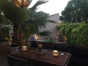 蒙彼利埃Villa avec piscine en plein cœur de ville的庭院内一张带蜡烛的木桌