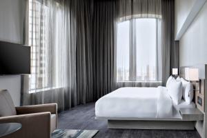 大急流城AC Hotel by Marriott Grand Rapids Downtown的卧室设有白色的床和大窗户