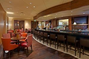 隆娜特里帕克梅多斯南丹佛万豪酒店的餐厅内的酒吧配有桌椅