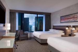 达拉斯Dallas Marriott Downtown的酒店客房设有两张床和大窗户。