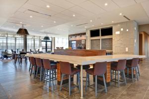 罗杰斯Courtyard by Marriott Bentonville Rogers Promenade的一个带大桌子和椅子的大厨房