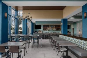 默特尔比奇Courtyard by Marriott Myrtle Beach Oceanfront的一间带桌椅的餐厅和一间酒吧