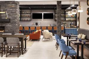 大草原城Delta Hotels by Marriott Grande Prairie Airport的一间带桌椅的餐厅和一间酒吧