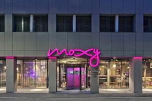 布加勒斯特Moxy Bucharest Old Town的建筑物前方的粉红色 ⁇ 虹灯标志