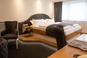 魏登斯塔德特库鲁格酒店的配有床、椅子和桌子的酒店客房