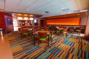 伍德斯托克Fairfield Inn & Suites by Marriott Atlanta Woodstock的一间设有桌椅的地毯餐厅