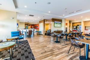 NewburghTownePlace Suites by Marriott Evansville Newburgh的一间带桌椅的餐厅和一间酒吧