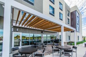 NewburghTownePlace Suites by Marriott Evansville Newburgh的大楼内带桌椅的天井